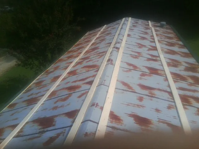 Rusted metal roof panels with new wood purlins before replacement — Storm Damage Roof Repair in North Newton by Roofing Brothers
