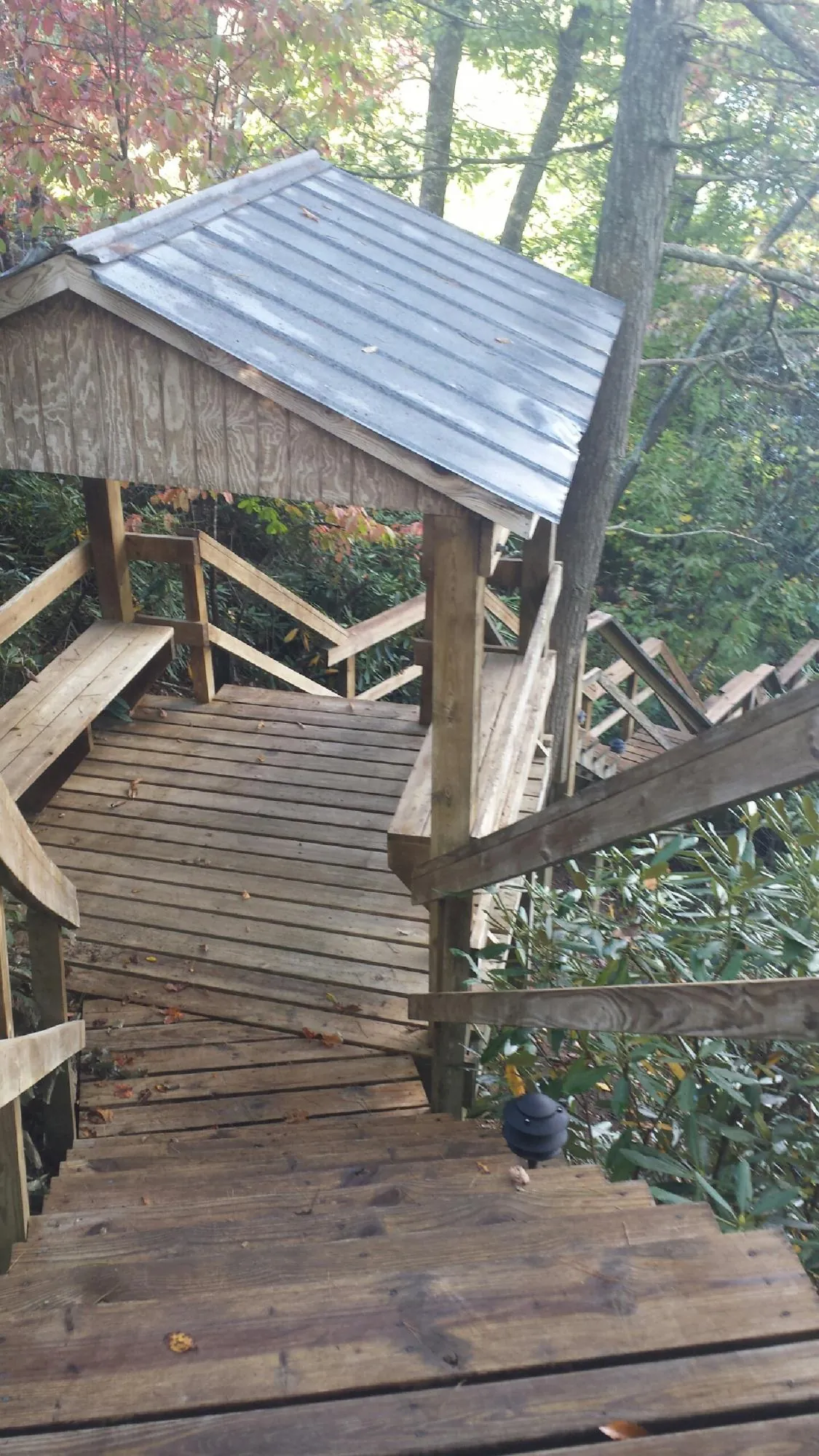 Metal roofed shelter over wooden steps on a wooded walkway — Skylight Repair & Installation work by our crew in North Newton