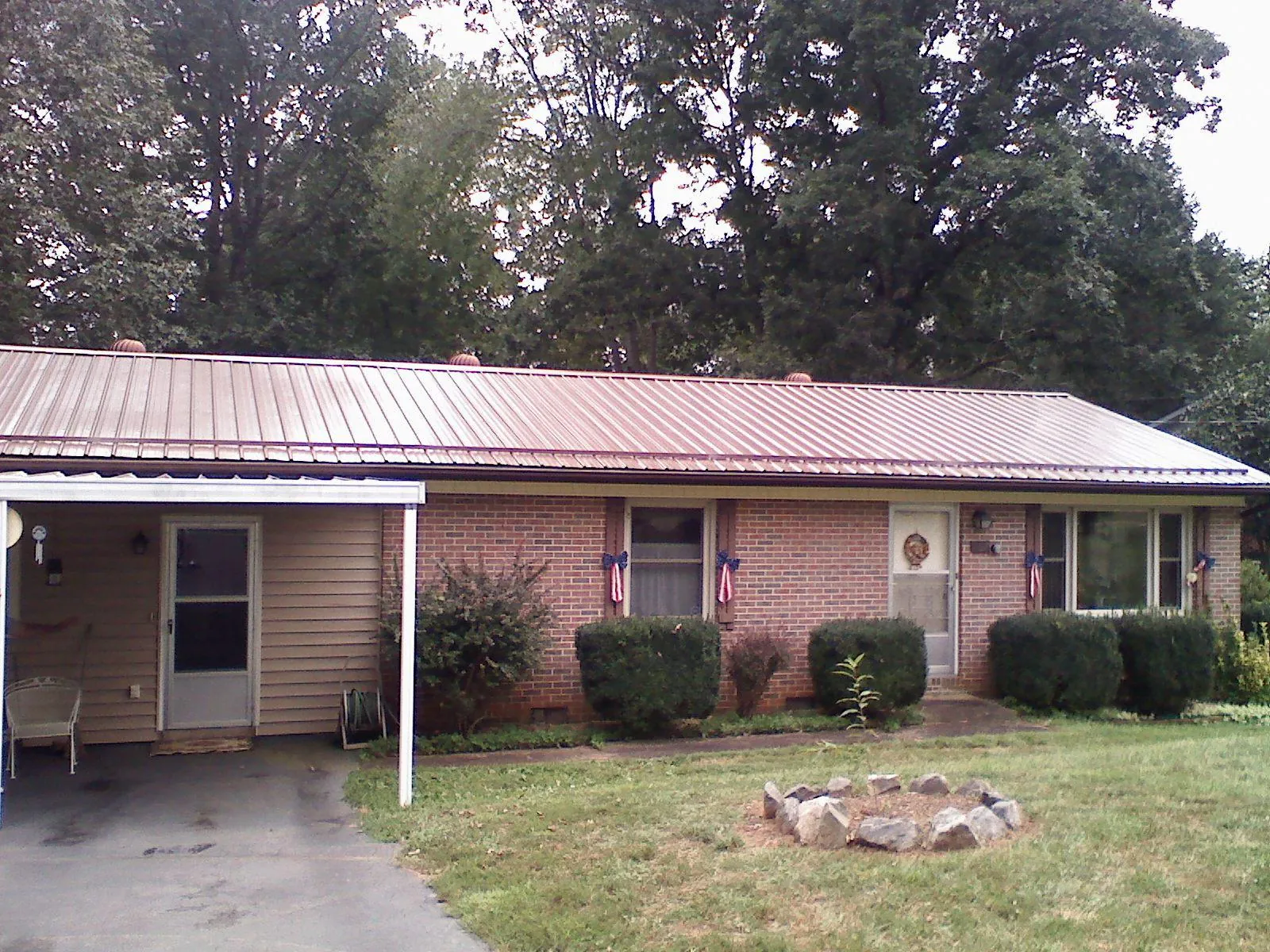 Bronze metal roof and carport on a brick ranch home — Roof Repair work by our crew in North Newton
